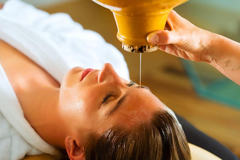 Woman enjoying a Ayurveda oil massage treatment in a spa